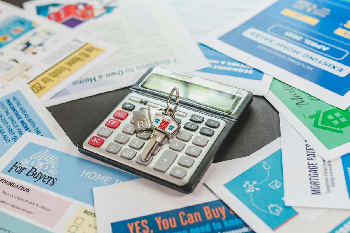 Calculator and house keys on mortgage-related documents.